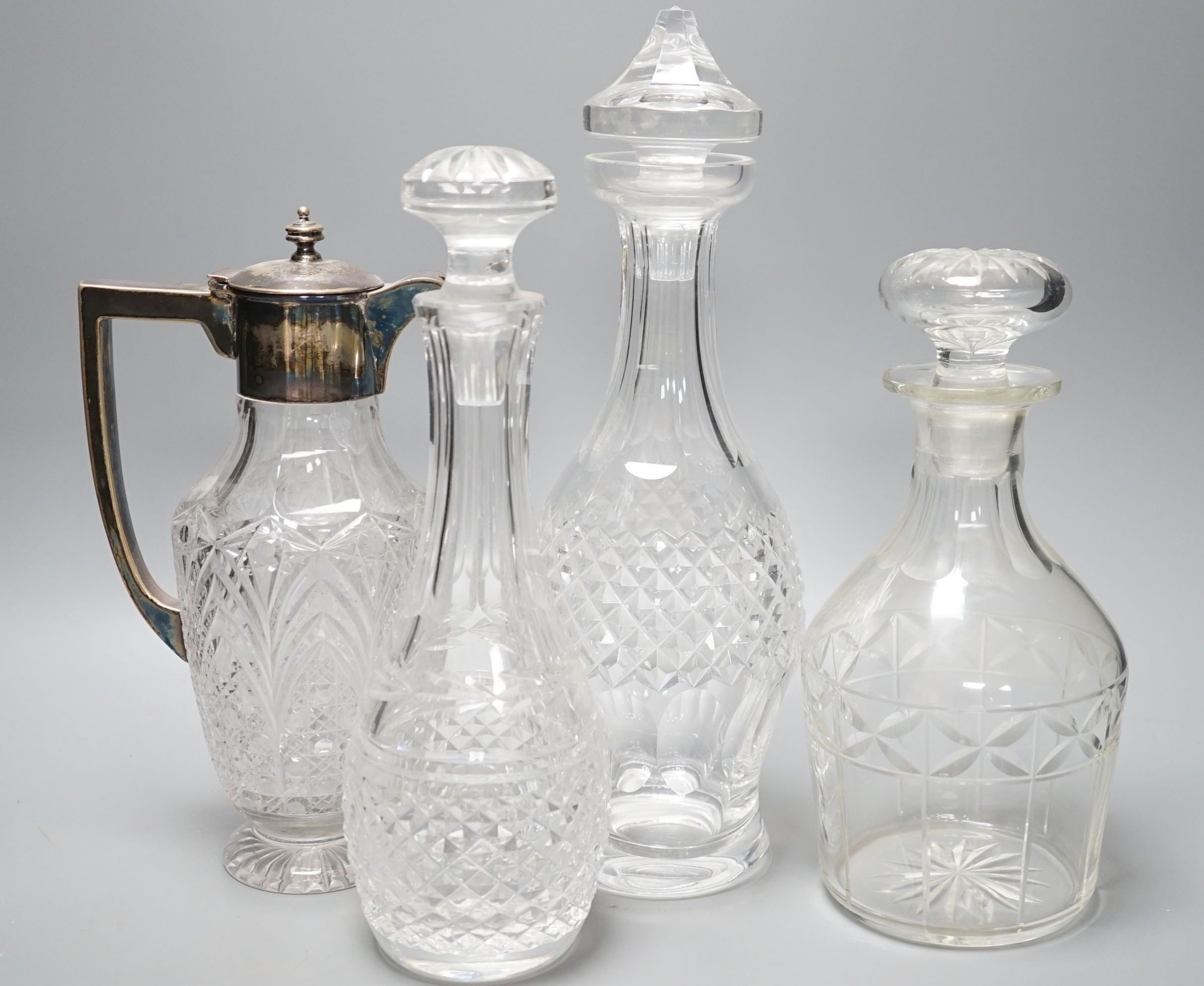 A group of assorted cut glass including decanters, a silver mounted claret jug, two milk jugs, tallest 33cm
